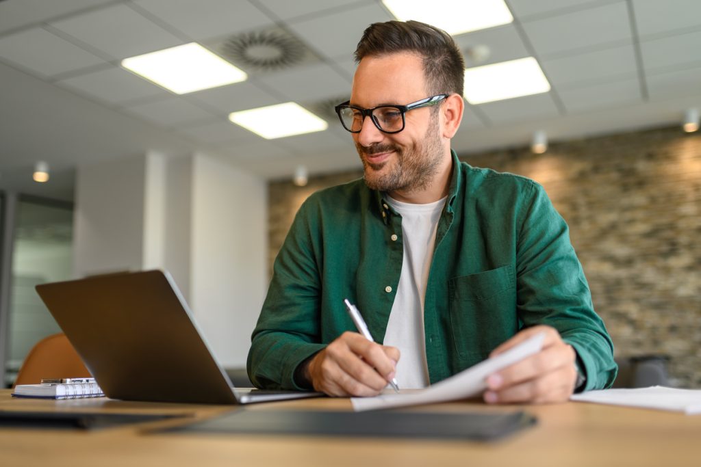 Professionnel analysant des documents afin d'évaluer des besoins en assurance de dommages.