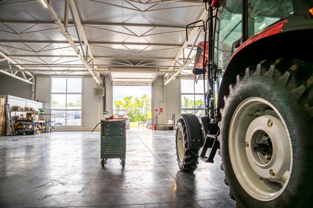 Farm tractor stored in a workshop during winter preparation and planning for the next season.